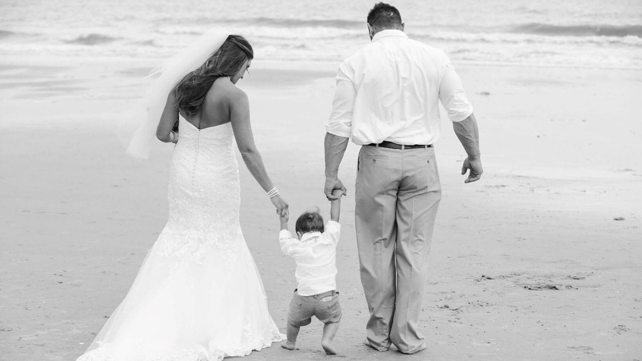 Bride, groom, and son on the beach