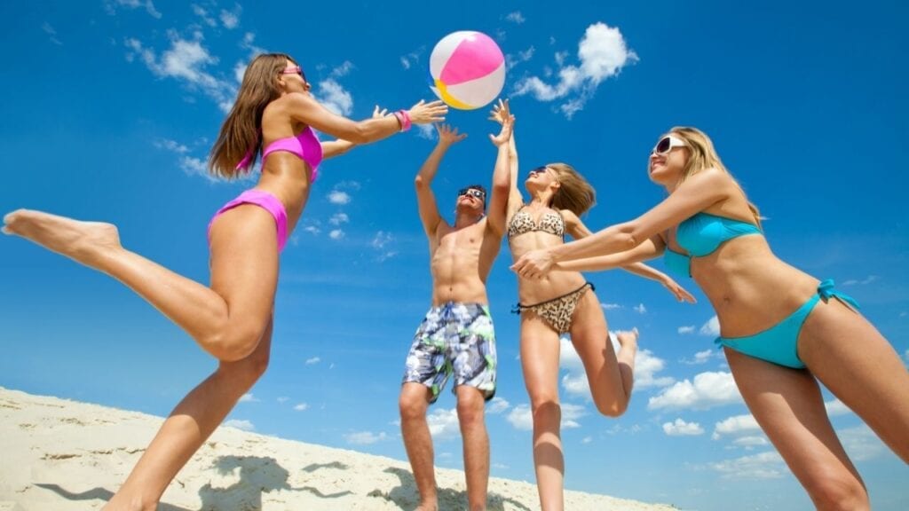 Teens playing beach volleyball