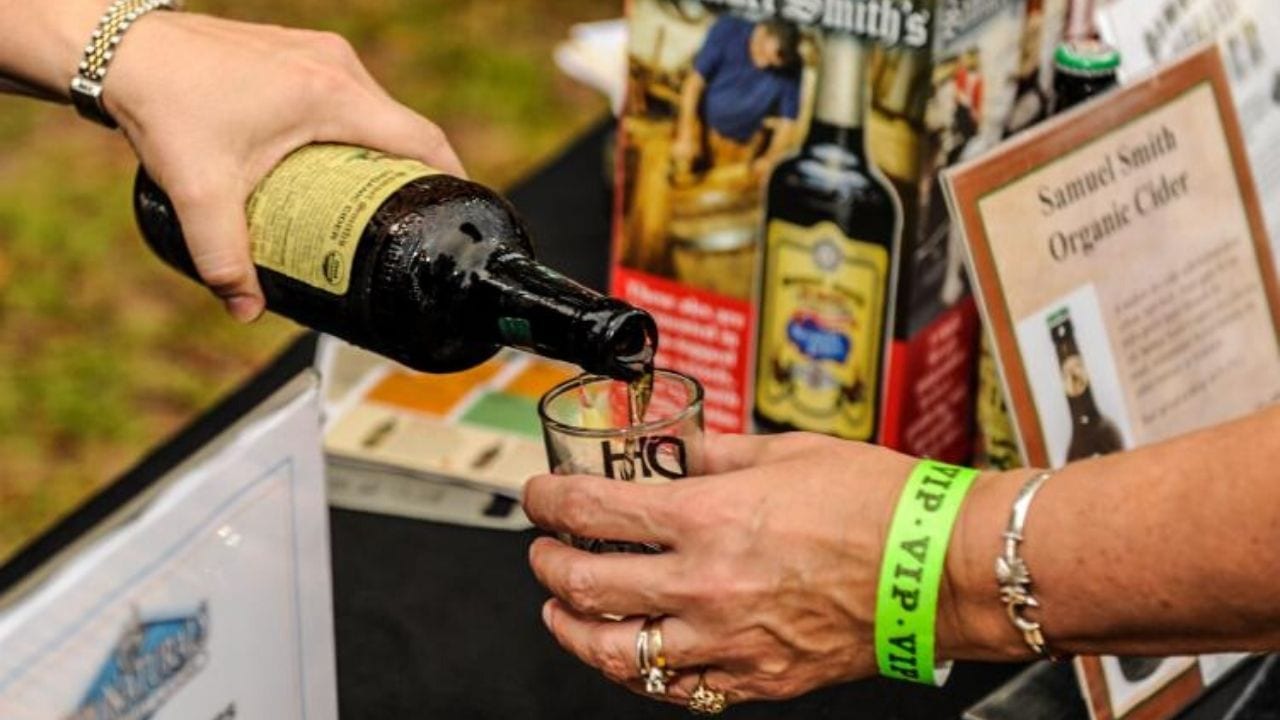 Woman pouring cider into a sample glass