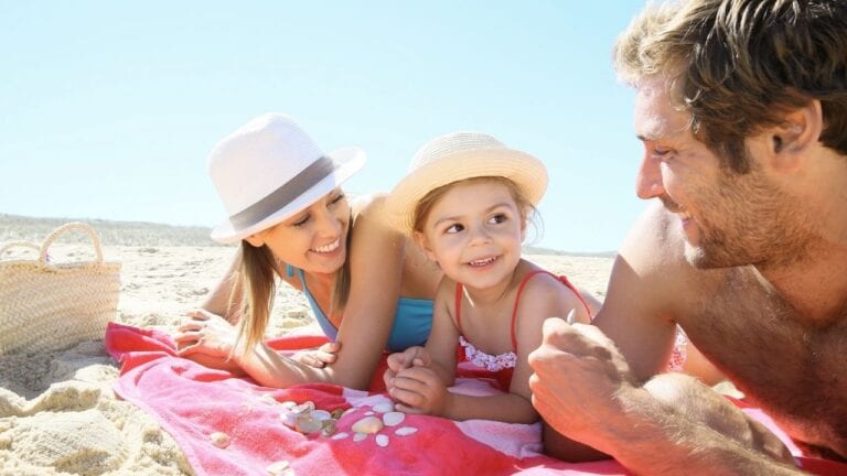 Family on a beach towel on sand